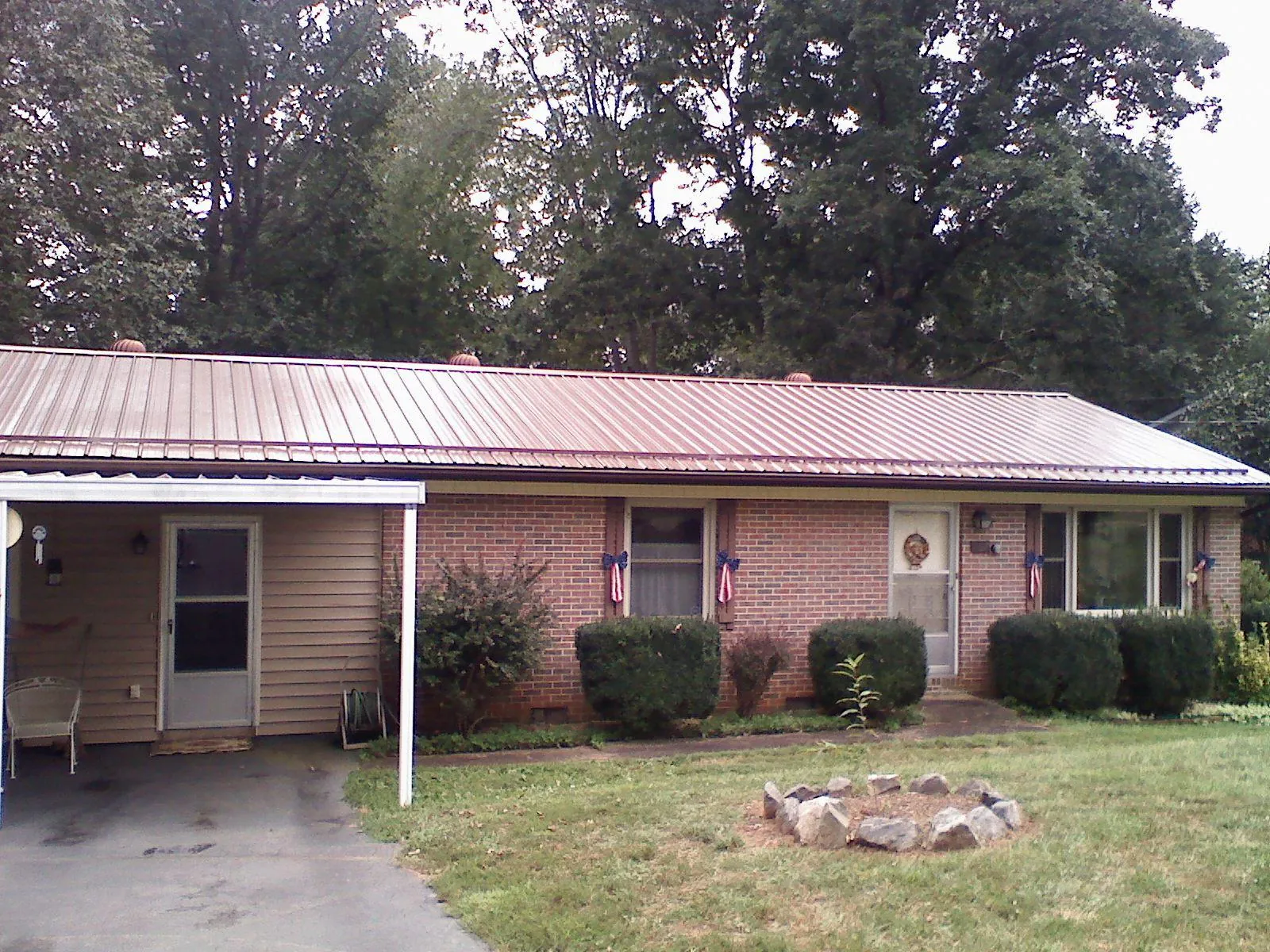 Bronze metal roof and carport on a brick ranch home — Roof Repair work by our crew in Burkeville